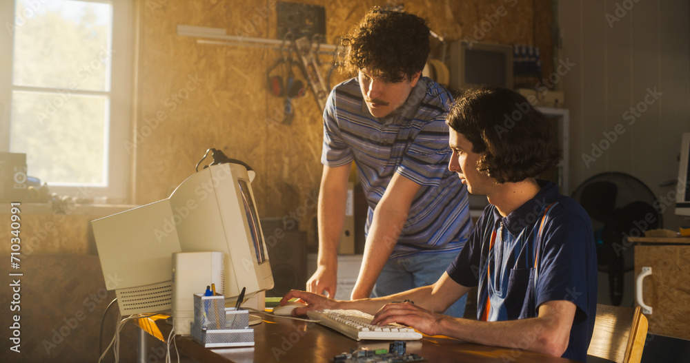 Aufkleber Two Caucasian Male Tech Startup Founders Using Old Desktop Computer In Retro Garage. Software Developer And User Experience Designer Starting New E-commerce Business In nineties. Nostalgia Concept.