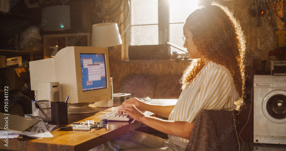 Poster Side View Of Hispanic Female Software Engineer Programming on Old Desktop Computer In Retro Garage. Focused Woman Starting Tech Startup Company In Nineties. Coding Innovative Online Service At Home.