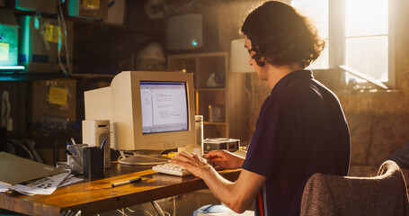 Caucasian Male Software Engineer Programming on Old Desktop Computer In Retro Garage. Focused Man...