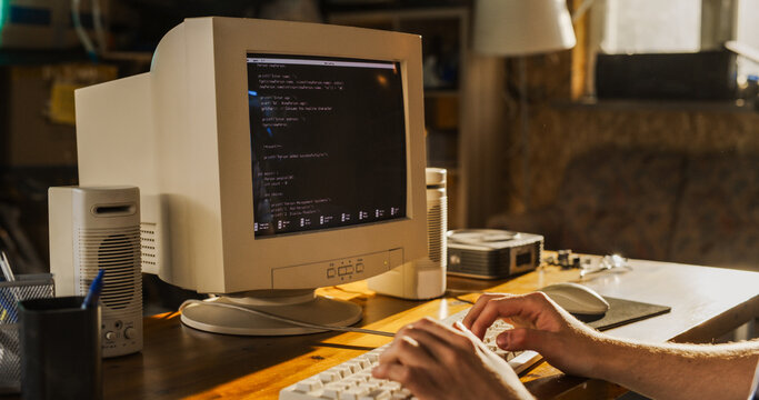 Caucasian Male College Student Using Old Desktop Computer In Nineties Retro Garage. Young Programmer Connecting World Wide Web Via Early Internet Software, Exploring Global Network.