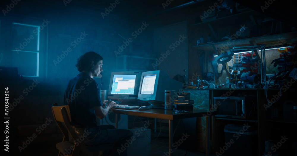 Leinwandbilder Caucasian Male Programmer Using Old Desktop Computer With Two Monitors In Retro Garage Late At Night. White Hat Hacker Searching For Software Vulnerabilities, Coding Cyber Security System In Nineties.