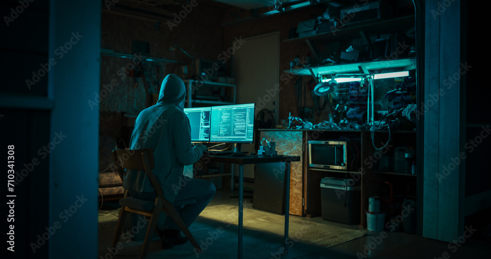 Poster home garage late at night: evil male hacker wearing hoodie breaks into data servers, ddos attack, ph