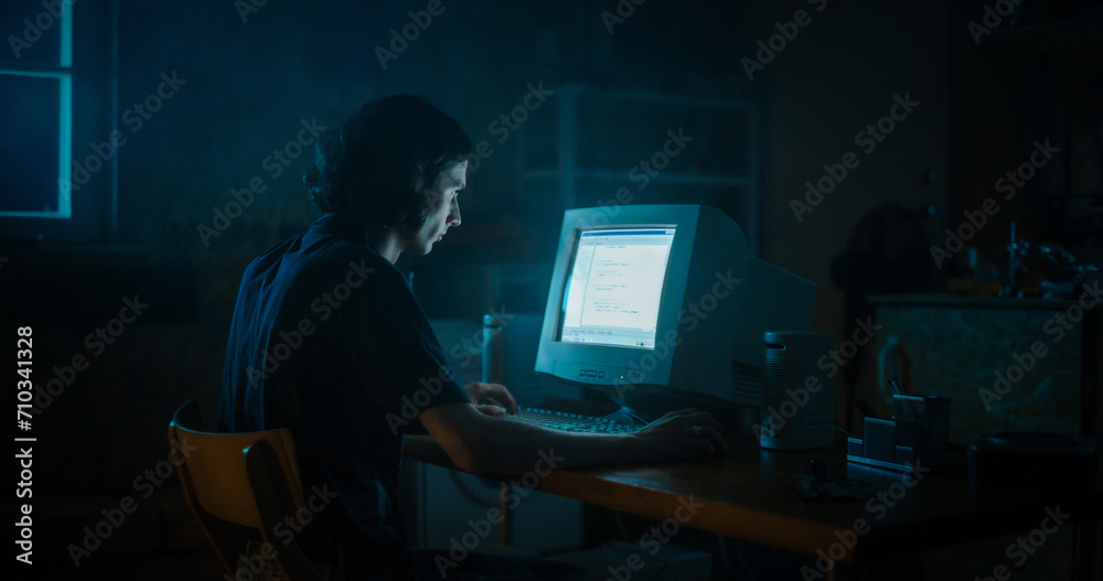 Leinwandbilder caucasian male web designer using old desktop computer in retro garage late at night. focused intern