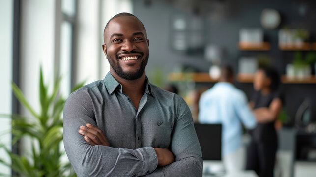 Portrait of a handsome smiling black businessman boss standing in his modern business company office.