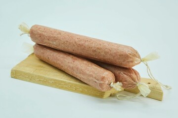 Dried sausages lie on a wooden board. The product is ready to use. White background.
