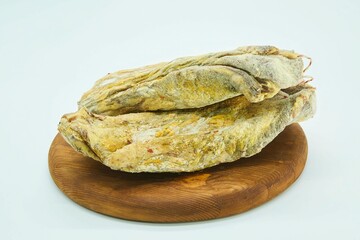 Obraz premium Dried meat without a shell in spices lies on a wooden board. The product is ready to use. White background.