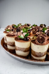 Tiramisu cups on a platter topped with chocolate decorations