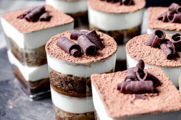 Closeup shot of tiramisu cups dessert topped with chocolate swirls