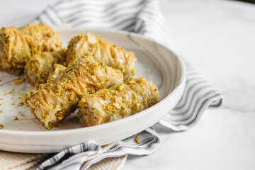 Closeup shot of the rolled baklava on a marble white plate