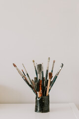 a collection of used old paint brushes against white background