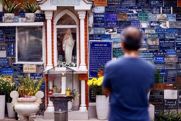 Huyen Si Church. Man praying the Virgin Mary. . Ho Chi Minh city. Vietnam.