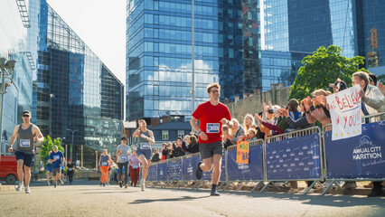 Diverse Group of People Competing in a Marathon Race in the City. Family and Friends in the Audience Cheering Enthusiastically and Supporting Their Loved Ones