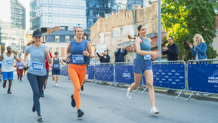 Portrait of a Smiling Group of People Participating in a City Marathon. Happy Female Friends Celebrating Together and Congratulating Each Other on Crossing the Finish Line in a Race