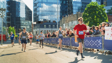 Diverse Group of People Competing in a Marathon Race in the City. Family and Friends in the...