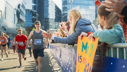Marathon Audience Supporting and Cheering Their Loved Ones Participating in the Race: Athletic Male...