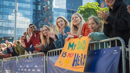 Little Girl and Her Mother Cheering for The Dad in the Audience of a City Marathon. Cute Family Holding a Motivating Banner to Support Their Loved One in a Race for Charity