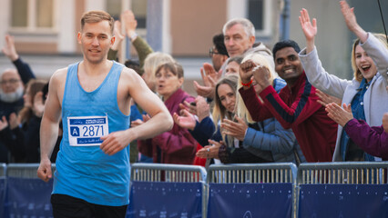 Portrait of Athletic Male Jogger and Supporters in the Audience While They Cheer for Him on a Marathon. Dedicated Friendly Man Participating in a Race, Focused on Winning