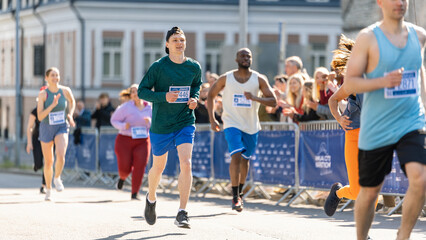 Obraz premium Smiling Group of People Participating in a City Marathon. Diverse Race Runners Reaching the Finish Line, Celebrating Their Victory and Achieving their Goal