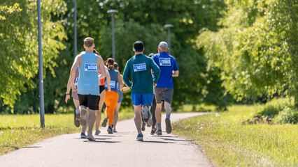 Wide Shot Back View of Diverse Marathon Participants Competing in a Race for the Finish Line: Group of People Running Through Park Health Trail and Participating in a Marathon with Dedication
