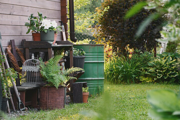 Gardener work bench (potting table) in summer garden with rainwater barrel. Wooden rustic style...