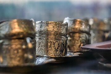Ornate handmade silver coffee cup holders at a traditional Turkish street coffee house cart in Eminonu Istanbul, Turkey