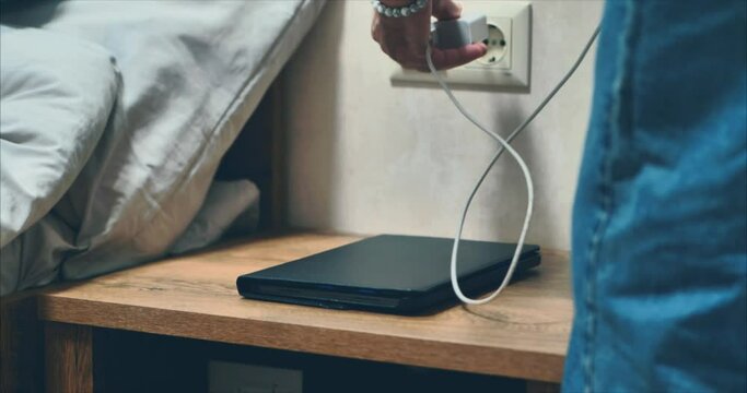 PaletteA man in a light sweater and jeans puts a tablet and phone on the bedside table. CINEMATOGRAPHIC EFFECT