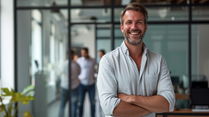 Fototapeta premium Portrait of a handsome smiling businessman boss standing in his modern business company office.