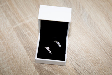 Beautiful golden silver wedding rings inside a white box for marriage couple on wooden table...