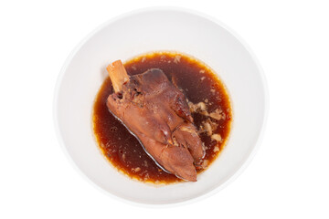 Pork knuckle or German pork hocks with vegetable and fruit served with sauce on chopping board and on wooden table.