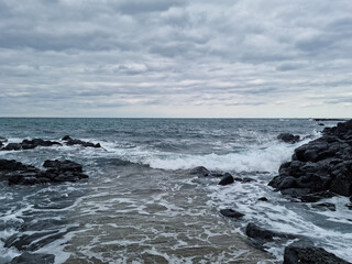 Fototapeta na wymiar The rough sea of ​​Jeju is covered in dark clouds.