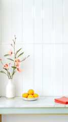 White modern kitchen setting with a vase of orchids and bowl of lemons