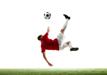 Art of airborne soccer. Dynamic portrait of young athletic man training kicking ball against white...