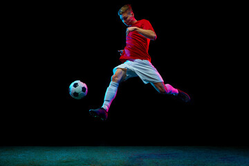 Perfect air kick. Professional soccer player sends ball soaring through air, moment frozen in time...