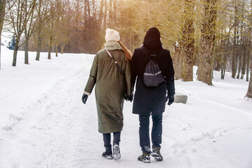 A guy and a girl walking in winter Park
