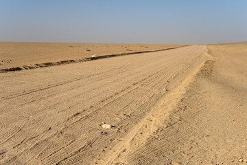 Fototapeta na wymiar gravel road in middle of nothing at desert of Moonlandscape, near Swakopmund, Namibia