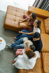 Asian family sitting and watching TV on the sofa. Inside the living room happily