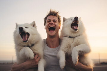 young man laughing with two huskies dogs