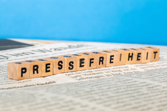 Symbolbild Pressefreiheit: Buchstabenwürfel auf einer Zeitung