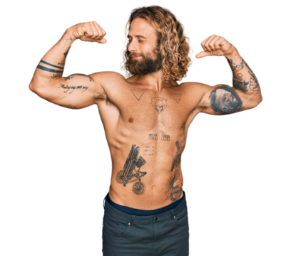 Handsome man with beard and long hair standing shirtless showing tattoos showing arms muscles smiling proud. fitness concept.