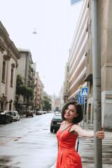 A female tourist walks through tourist places. Sightseeing. Dressed in comfortable travel clothes. Girl laughs, enjoys the journey