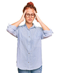 Young redhead woman wearing casual clothes and glasses suffering from headache desperate and stressed because pain and migraine. hands on head.