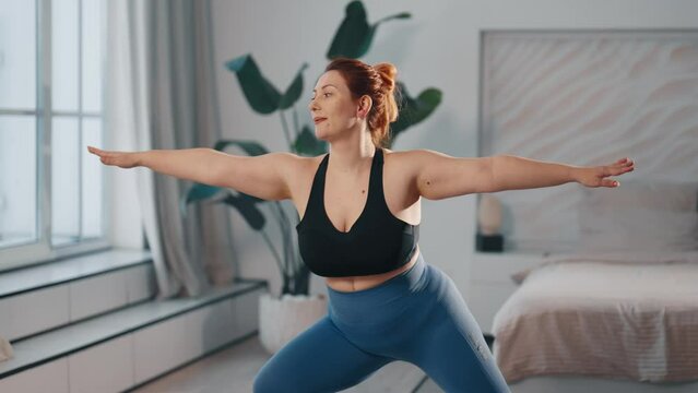 Woman training exercising at home. Middle aged female fitness newcomer doing body rotations exercises to keep herself in shape, to lose weight. Sport, healthy lifestyle, workout, wellness concept.
