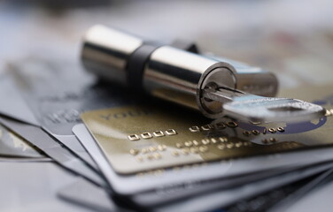 Lock with key rests on plastic credit cards. Banking security and fraud concept