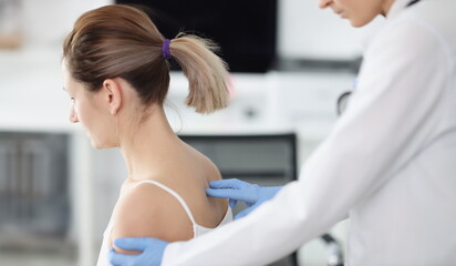 Doctor examines patient's spine in medical office. Spine disease symptoms and treatment concept