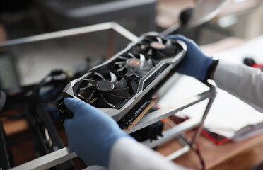 Serviceman holds a video card for a mining farm in his hands concept