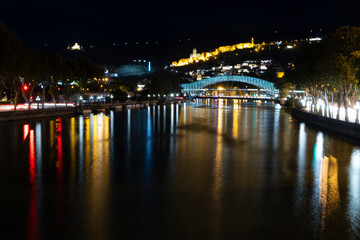 Fototapeta na wymiar Panoramic landscape of downtown Tbilisi at night with church and bridge of peace