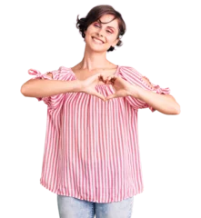 Poster Beautiful young woman with short hair wearing casual summer clothes smiling in love doing heart symbol shape with hands. romantic concept. © Krakenimages.com