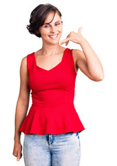 Fototapeta premium Beautiful young woman with short hair wearing casual style with sleeveless shirt smiling doing phone gesture with hand and fingers like talking on the telephone. communicating concepts.