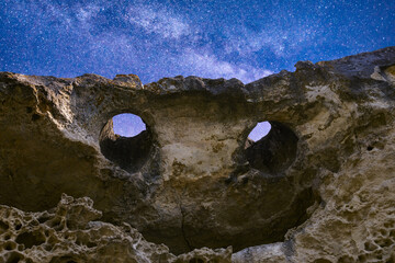 Night landscape, smiling rock against the background of the night sky with the milky way. eyes of god