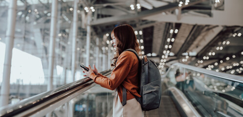 Young asian woman in international airport terminal or modern train station. Backpacker passenger...